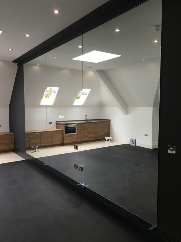 Frameless glass partition in loft conversion by Wolverton glaziers
