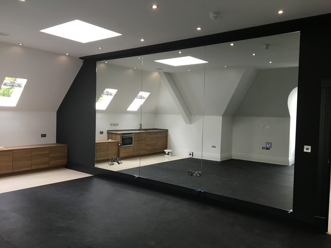 Frameless glass wall dividing loft conversion in Wolverton